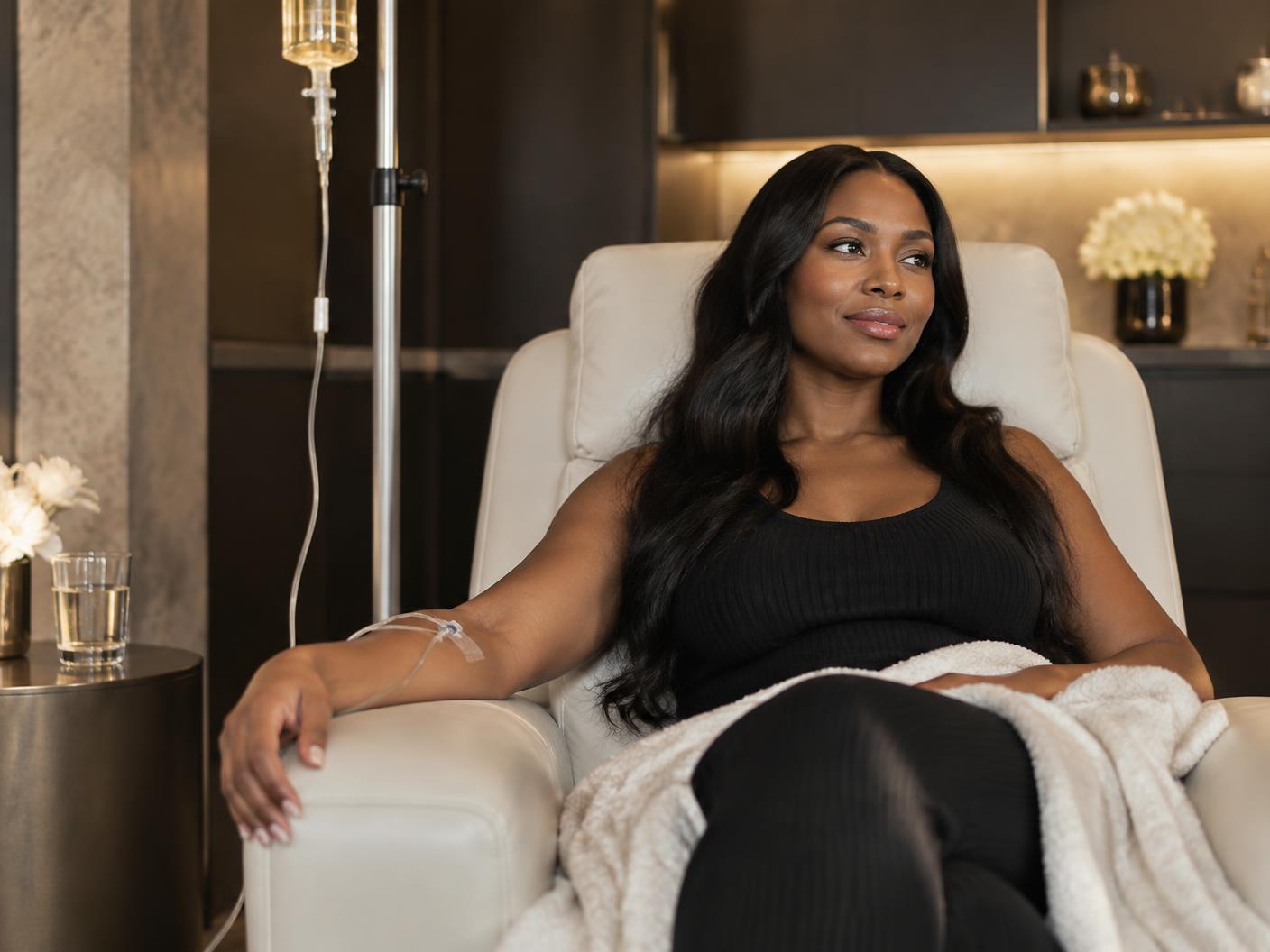 Black woman receiving IV hydration in a refined wellness setting